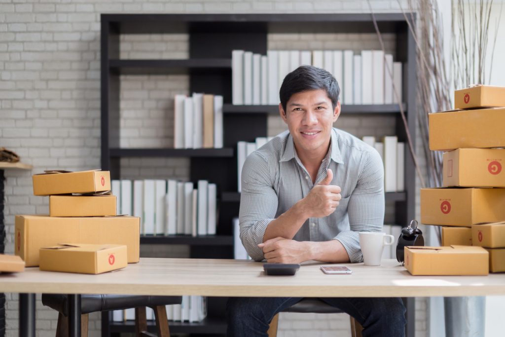 happiness business owner with box product and laptop on table successful business ideas concept